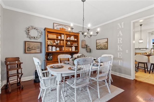 dining room featuring dark hardwood / wood-style flooring, ornamental molding, and a notable chandelier