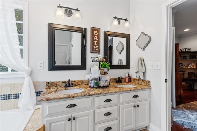 bathroom with vanity and tiled bath