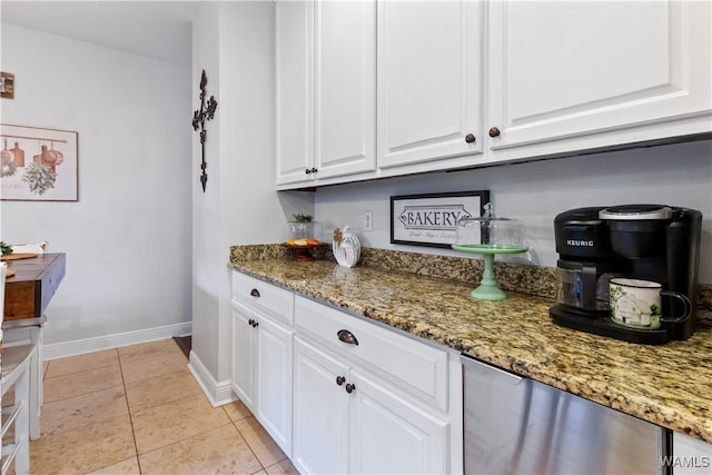 kitchen with white cabinets, light tile patterned floors, and dark stone countertops