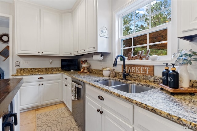 kitchen featuring white cabinetry, sink, dishwasher, dark stone counters, and light tile patterned flooring