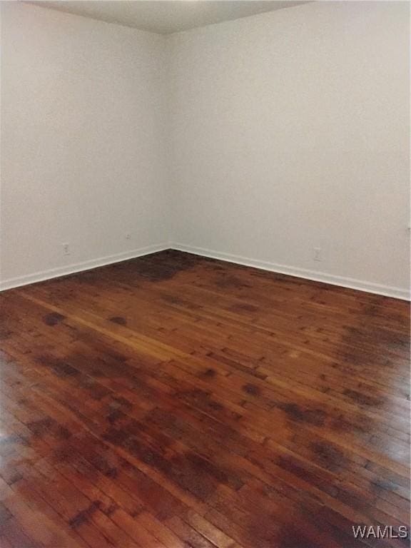 spare room featuring dark wood-type flooring