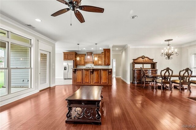 living area with dark wood-style flooring, recessed lighting, visible vents, and ceiling fan with notable chandelier