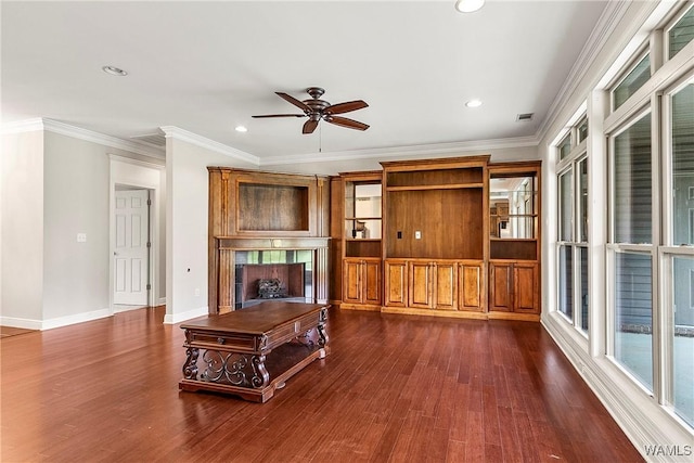 unfurnished living room featuring dark wood-style flooring, visible vents, ceiling fan, crown molding, and a fireplace