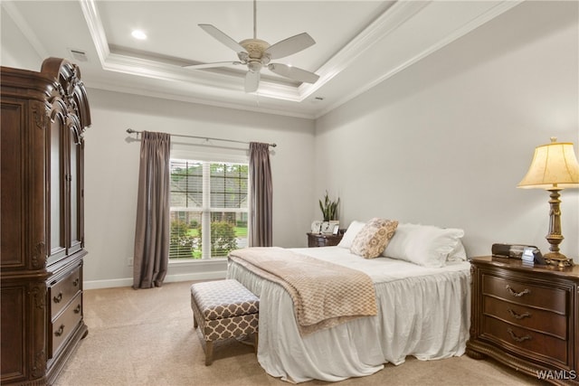 carpeted bedroom with ceiling fan, a raised ceiling, and ornamental molding