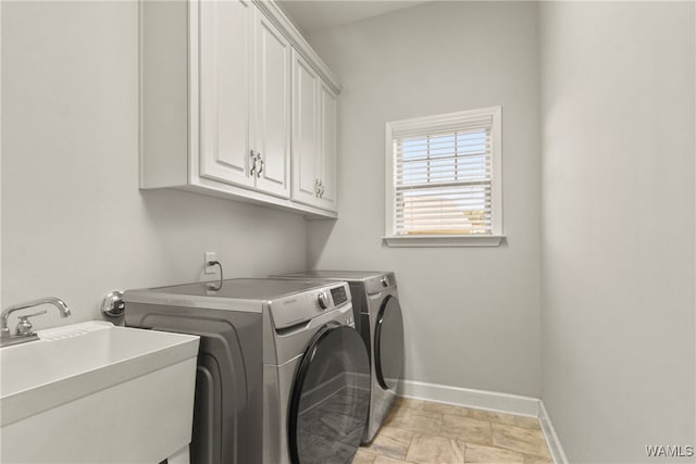 laundry room featuring cabinets, separate washer and dryer, and sink