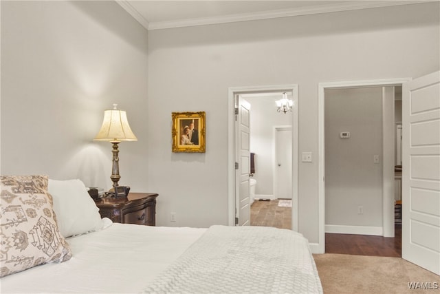 carpeted bedroom with connected bathroom and ornamental molding