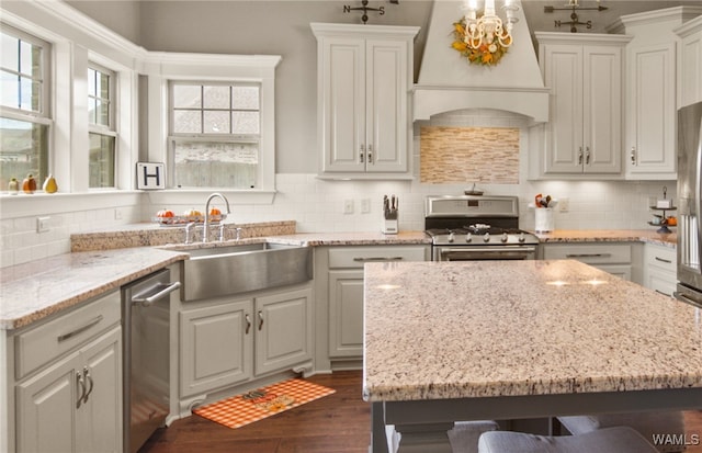 kitchen with appliances with stainless steel finishes, sink, plenty of natural light, and custom exhaust hood