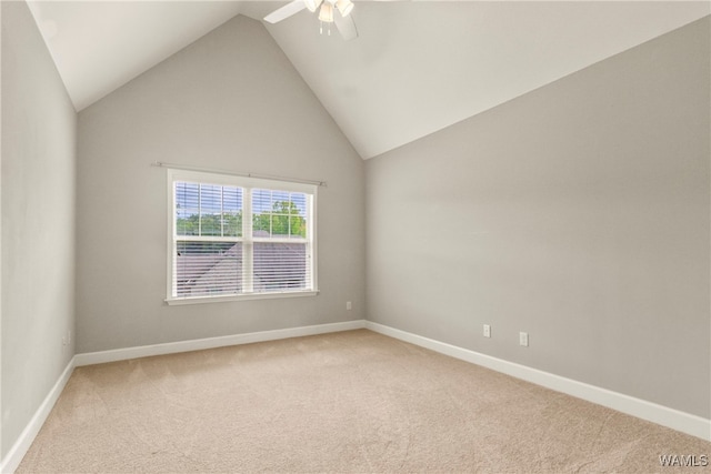 carpeted spare room featuring high vaulted ceiling and ceiling fan