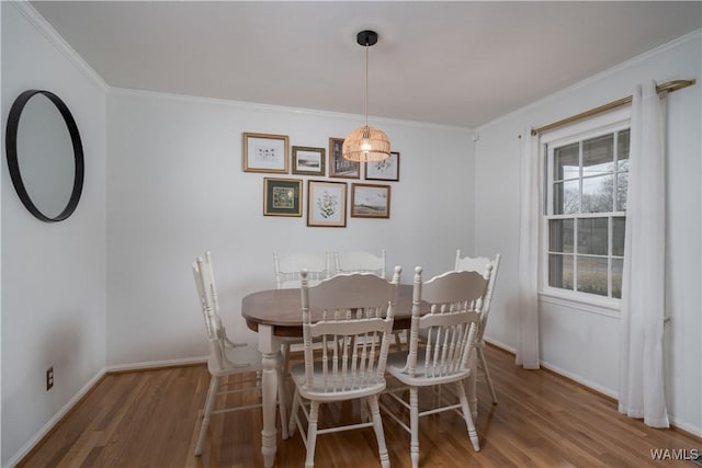 dining space with wood-type flooring and ornamental molding