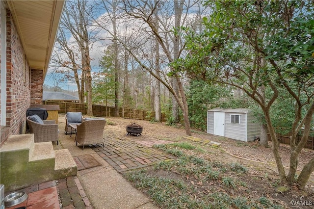 view of yard with an outdoor living space with a fire pit, a patio area, and a storage shed