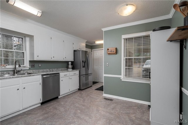 kitchen with sink, white cabinetry, a textured ceiling, ornamental molding, and appliances with stainless steel finishes