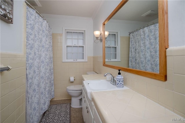 bathroom with tile walls, vanity, tile patterned floors, and ornamental molding