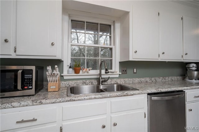 kitchen featuring stainless steel appliances, sink, and white cabinets