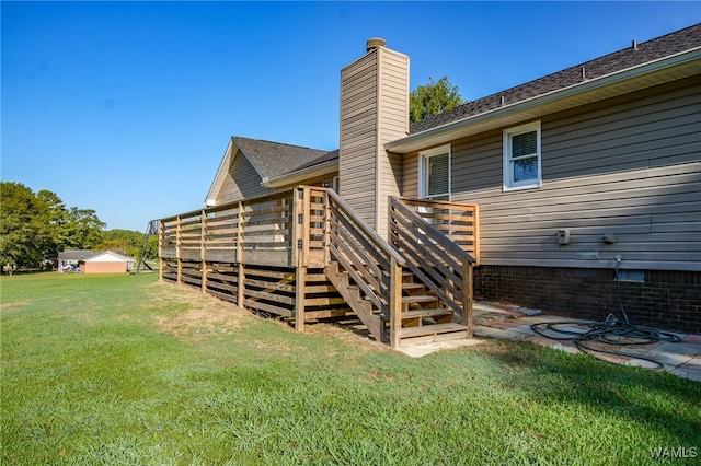 rear view of house featuring a deck and a lawn