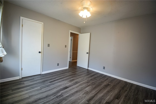 unfurnished bedroom featuring dark hardwood / wood-style floors, ceiling fan, a textured ceiling, and a closet