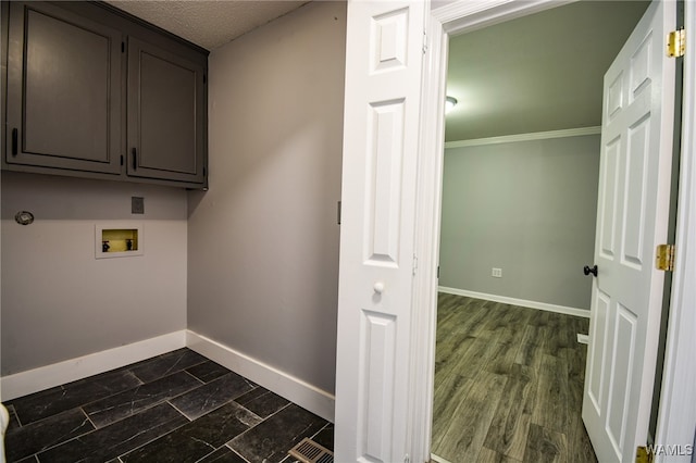 laundry area featuring cabinets, washer hookup, dark hardwood / wood-style flooring, and crown molding