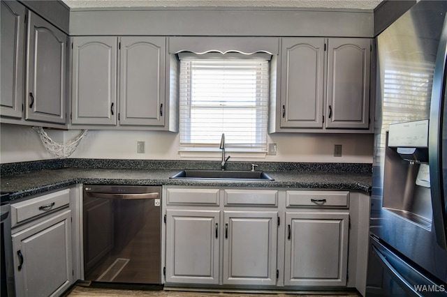 kitchen with stainless steel appliances, gray cabinetry, and sink