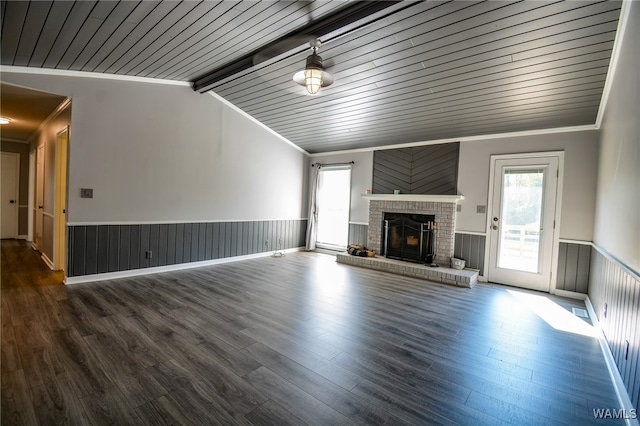 unfurnished living room with crown molding, plenty of natural light, lofted ceiling with beams, and hardwood / wood-style flooring