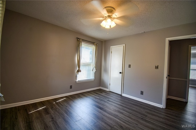 empty room with a textured ceiling, ceiling fan, and dark wood-type flooring