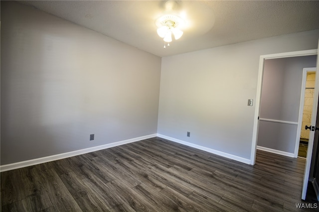 empty room featuring a textured ceiling, dark hardwood / wood-style floors, and ceiling fan