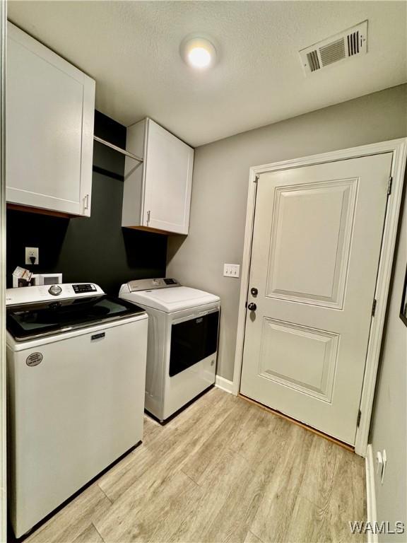 6643 Cooperstown Cir, Tuscaloosa, AL 35453 - washroom with cabinet space, washer and dryer, light wood finished floors, and baseboards