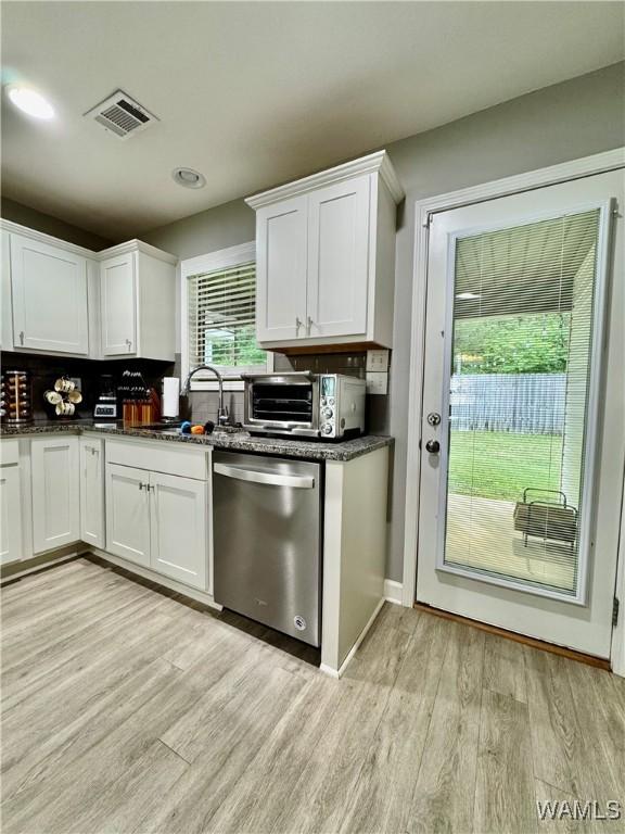 6643 Cooperstown Cir, Tuscaloosa, AL 35453 - kitchen with stainless steel dishwasher, a sink, white cabinetry, and light wood-style floors