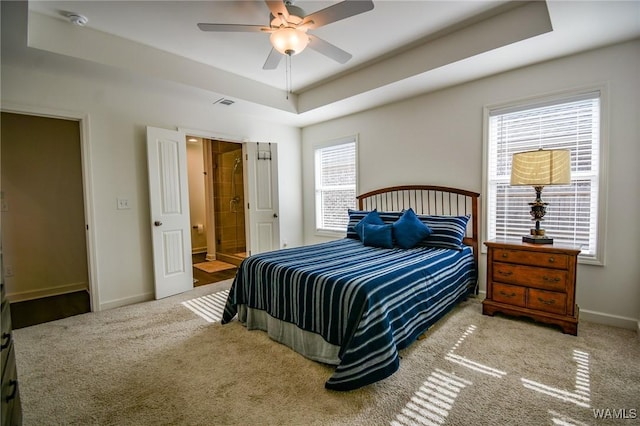 bedroom featuring carpet floors, a tray ceiling, visible vents, and baseboards