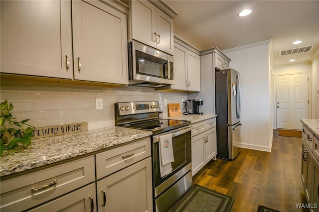 kitchen featuring tasteful backsplash, visible vents, dark wood finished floors, light stone counters, and appliances with stainless steel finishes