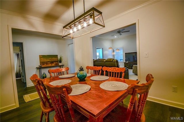 dining room featuring a ceiling fan, crown molding, baseboards, and wood finished floors