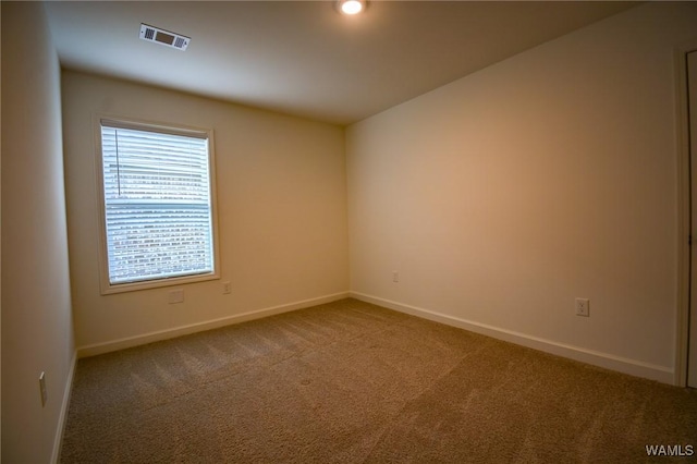 unfurnished room featuring carpet, visible vents, and baseboards