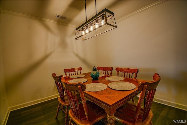 dining space featuring ornamental molding, wood finished floors, visible vents, and baseboards