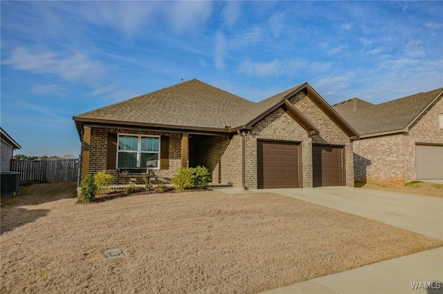 view of front of house with concrete driveway, brick siding, an attached garage, and cooling unit