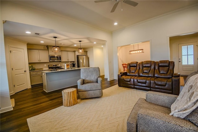 living area with a ceiling fan, ornamental molding, dark wood-type flooring, and recessed lighting