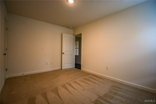 unfurnished room featuring carpet flooring and baseboards