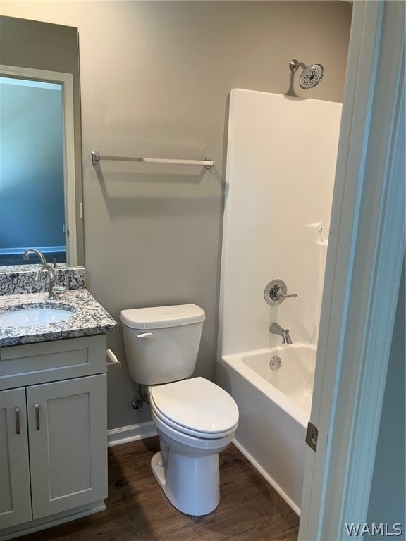 full bathroom featuring hardwood / wood-style floors, vanity, toilet, and shower / washtub combination