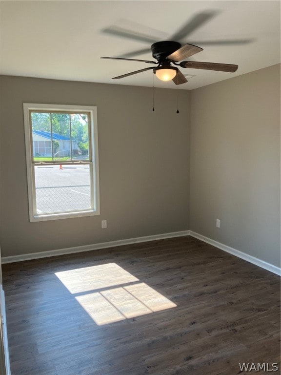 spare room with dark hardwood / wood-style floors and ceiling fan