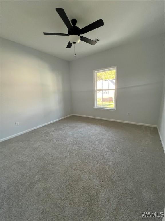 spare room featuring carpet flooring and ceiling fan