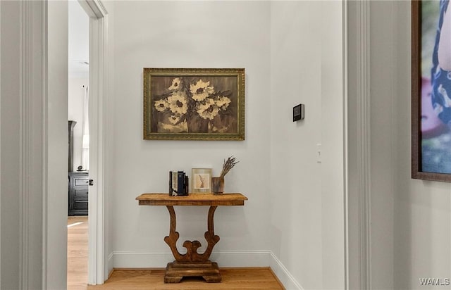 corridor featuring baseboards and wood finished floors