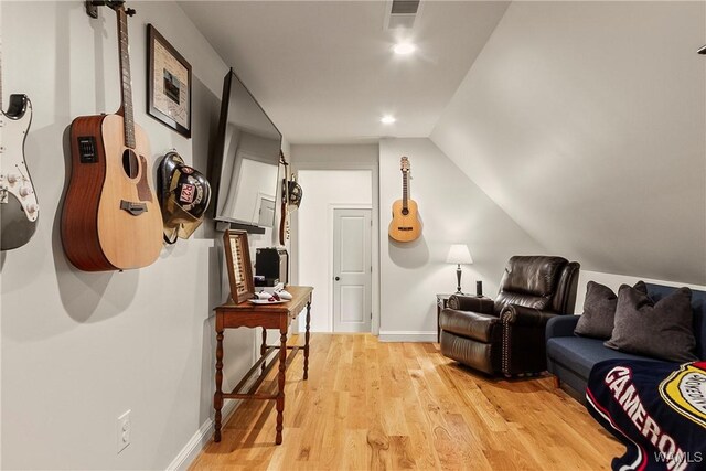 interior space with light wood finished floors, visible vents, baseboards, and vaulted ceiling