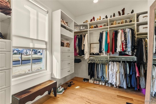 walk in closet with wood finished floors