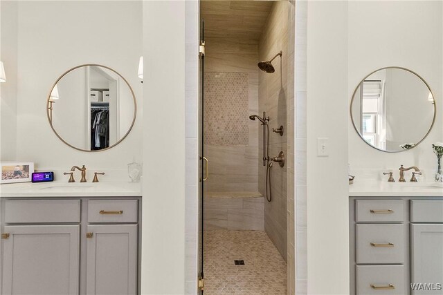 full bathroom featuring two vanities, a stall shower, and a sink