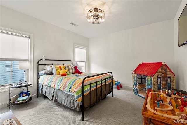 bedroom with carpet, visible vents, a chandelier, and baseboards