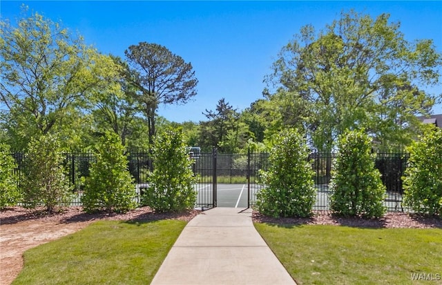 view of home's community with fence and a lawn