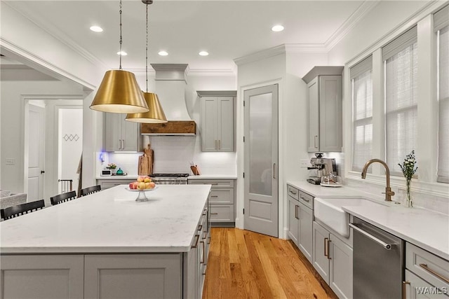 kitchen with premium range hood, a sink, gray cabinetry, stainless steel dishwasher, and a center island