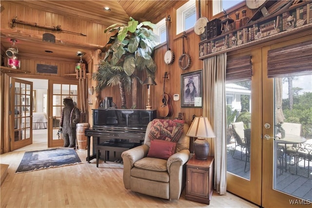 sitting room featuring wooden ceiling, wooden walls, wood finished floors, and french doors