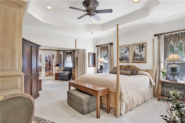 bedroom featuring recessed lighting, light carpet, french doors, ornamental molding, and a tray ceiling