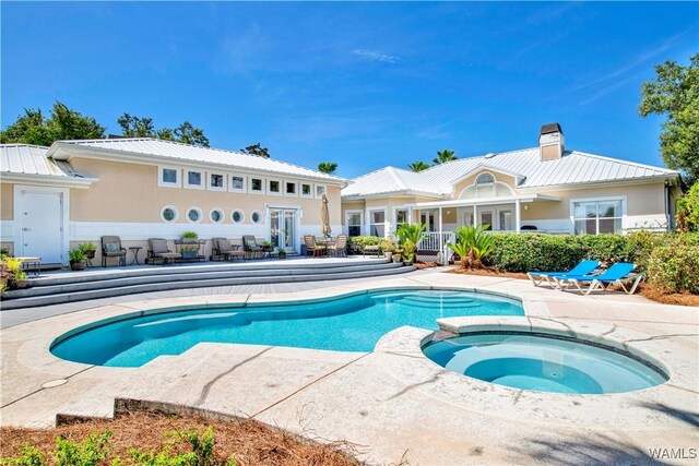 view of pool featuring a pool with connected hot tub, french doors, and a patio