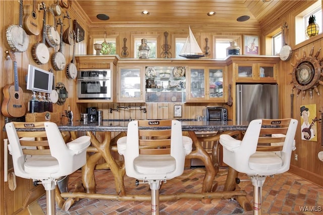 interior space with wooden ceiling, brick floor, and wood walls