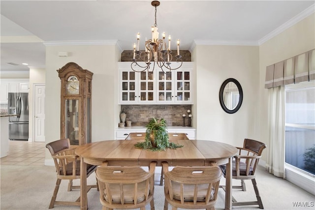 dining space with a chandelier, light colored carpet, crown molding, and baseboards