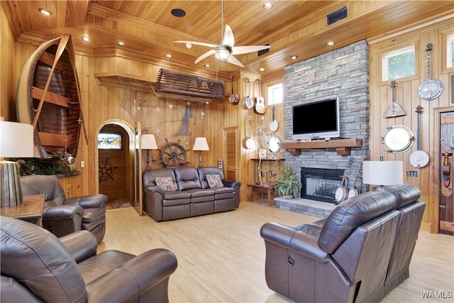 living room featuring wooden walls, wood ceiling, and a stone fireplace